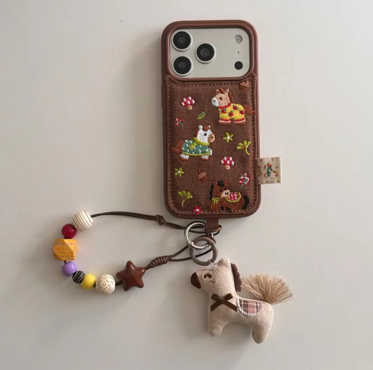 Embroidered Three Ponies phone case for iPhone 17 and 16 Pro by HSF Marketplace