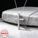 S925 sterling silver cross pendant necklace with cubic zirconia stones on a jewelry display