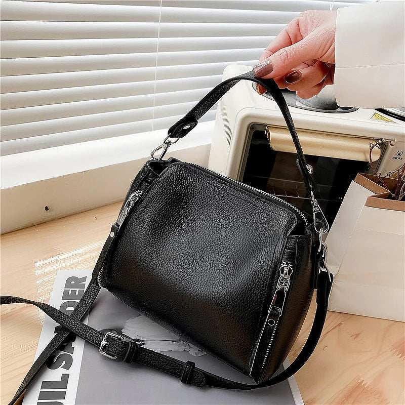 Luxury genuine leather women's messenger handbag with high capacity, crossbody style, and shoulder strap in cowhide design.