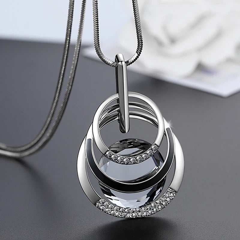 Elegant geometric crystal statement necklace with long pendant, pearls, and modern design for women, perfect for fashionable jewelry looks.