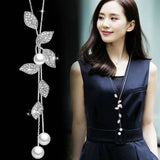 Elegant geometric crystal pendant necklace with long chain and pearl accents, stylish jewelry for women.