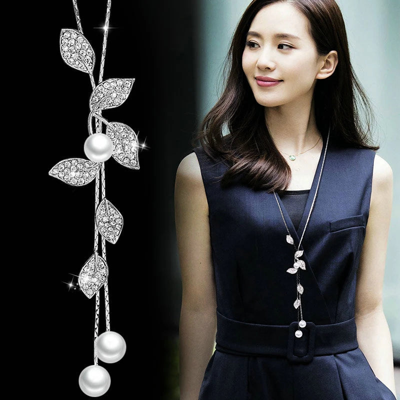Elegant geometric crystal pendant necklace with long chain and pearl accents, stylish jewelry for women.
