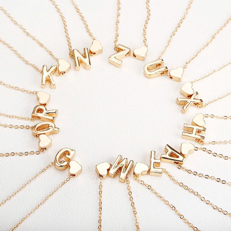 Dainty initial necklace with tiny heart pendant, gold-tone jewelry for women, featuring letter charm, perfect for gift or everyday wear.