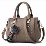 Leather embroidery messenger bag for women, stylish handbag with hair ball detail, versatile purse for daily use.