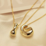Golden stainless steel initial necklace for women with chunky bubble letter pendant, trendy jewelry gift for girls and women.
