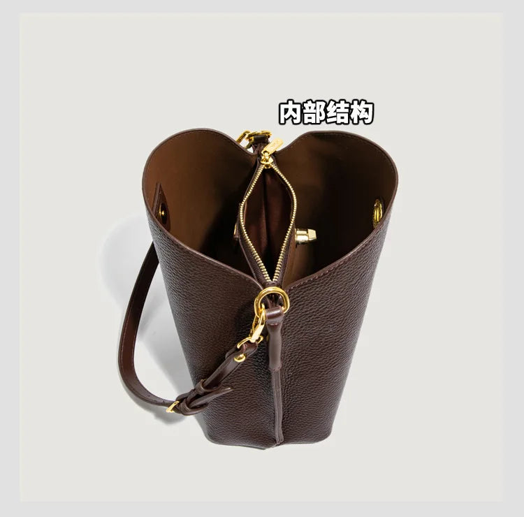 Elegant burgundy PU leather women’s handbag with large capacity bucket design, shoulder strap, and stylish tote appearance.
