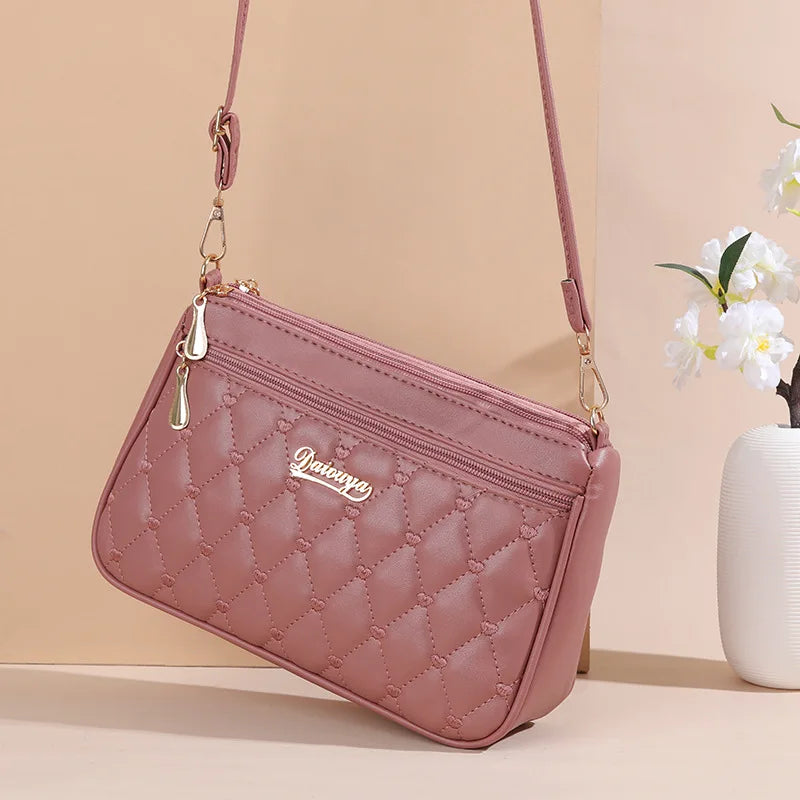Elegant black PU leather crossbody handbag with embroidery thread detail, zipper closure, and spacious interior for women.