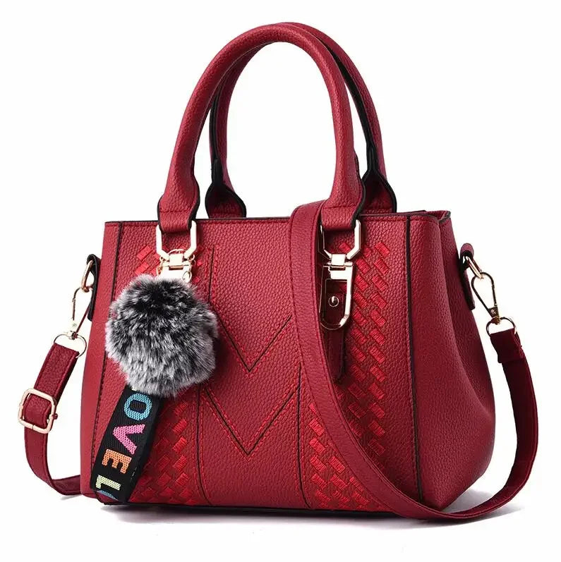 Leather embroidery messenger bag for women with hairball detail, stylish handbag perfect for everyday use.