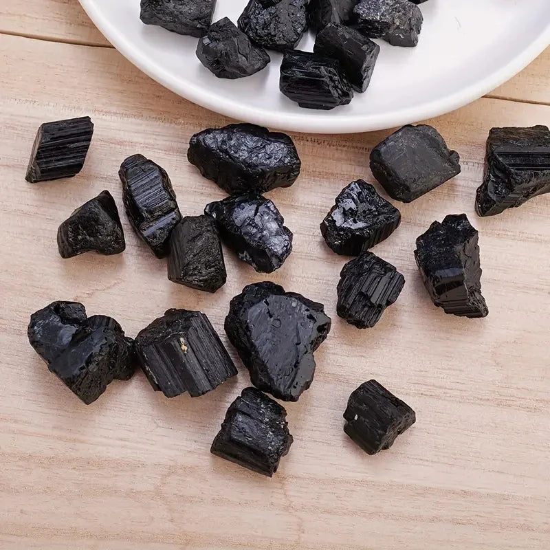 Raw black tourmaline crystal stones in a 100g bag, irregular mineral specimen with natural black mineral ore texture.