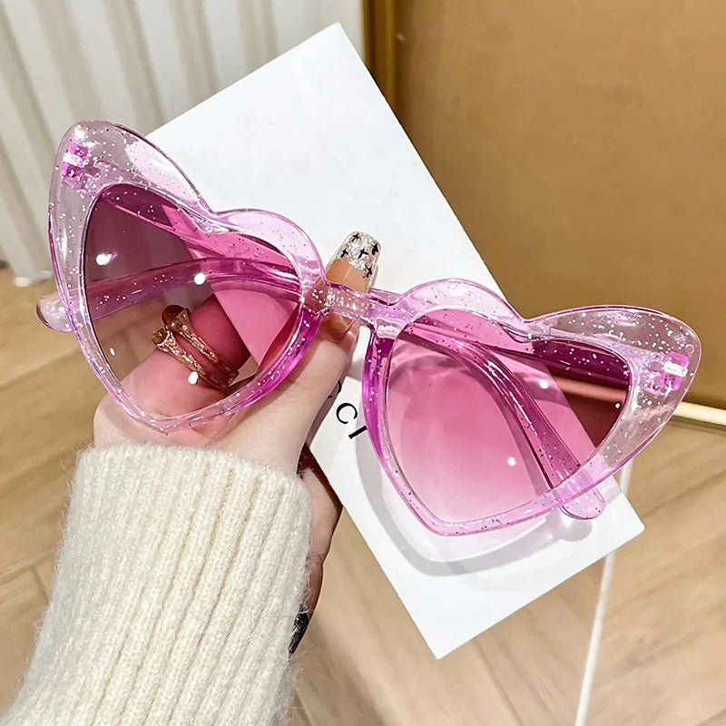Pink heart-shaped transparent sunglasses by HSF Marketplace, shiny retro style perfect for beach parties and photos.