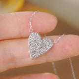 Huitan heart pendant necklace with sparkling CZ stones for women, shown on a jewelry display