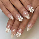 White almond-shaped press-on false nails with handmade bow and pearl decorations by HSF Marketplace