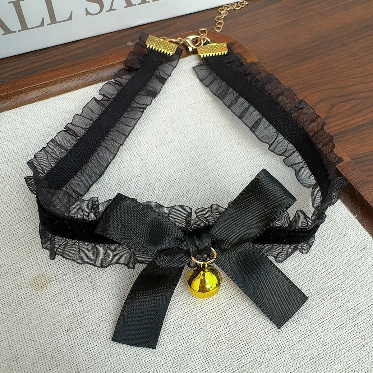 Cute women's gothic lace choker necklace with bow and bell pendant, featuring a simple, sexy, and fashionable jewelry design.
