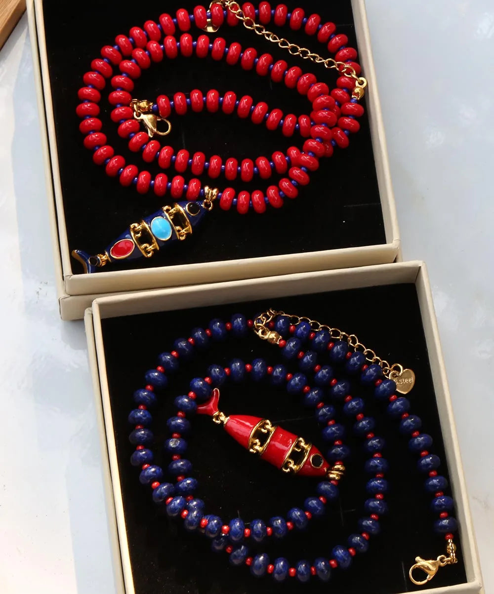 Red and blue beaded necklace with multi-layer fish pendant, natural stone beads, stainless steel accents, and glazed finish.