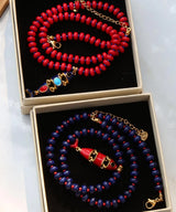 Red and blue beaded necklace with multi-layer fish pendant, natural stone beads, stainless steel accents, and glazed finish.