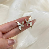 White enamel butterfly stud earrings with crystal wings in golden color metal for women