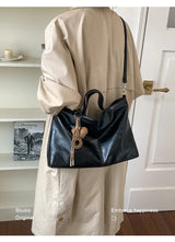 Luxury black PU leather women's handbag with spacious interior, shoulder strap, and stylish design for commuting and office use.