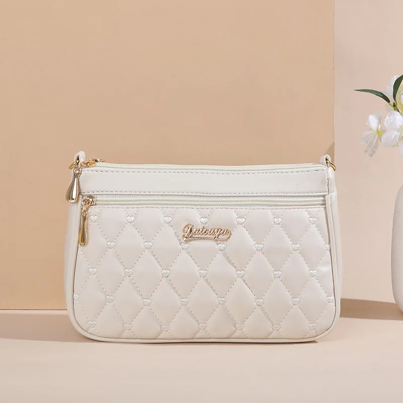 Holographic PU leather crossbody handbag with zipper closure, embroidered details, and spacious interior for women’s fashion accessory