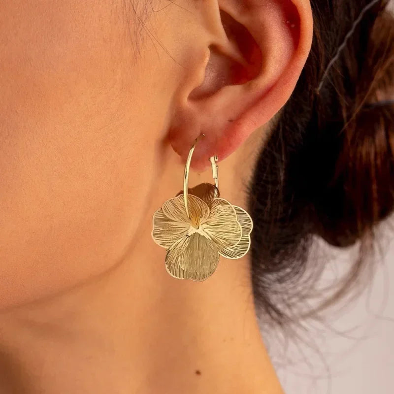 Stainless steel golden double-layer hollow flower hoop earrings for women, vintage floral jewelry close-up