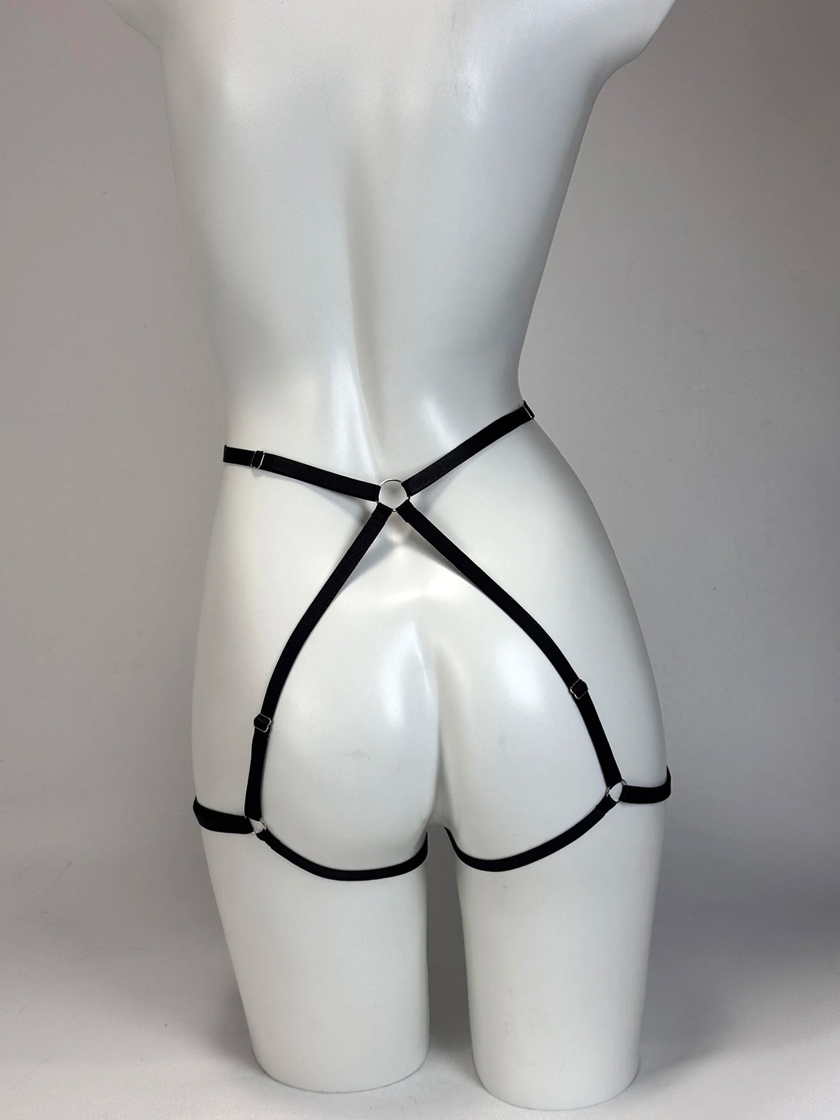 Black gothic punk elastic harness belt with adjustable waist and thigh straps, shown as a body accessory.