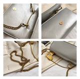 Red retro metal pin design women’s crossbody handbag made of PU leather with chain strap and clutch style from HSF Marketplace.