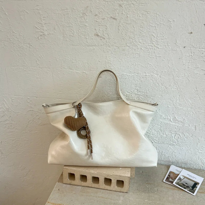 Luxury PU leather casual women's handbag with spacious interior, shoulder strap, and elegant design for commuting and office use.