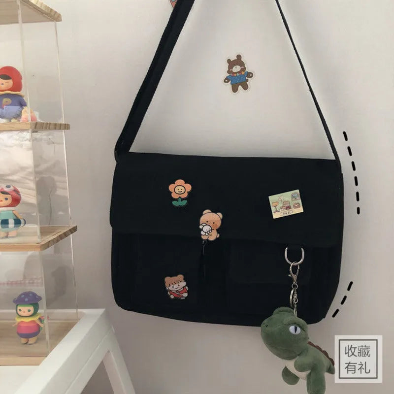 Women’s casual canvas messenger bag with printed design, featuring shoulder strap and pouch for everyday use and school essentials.