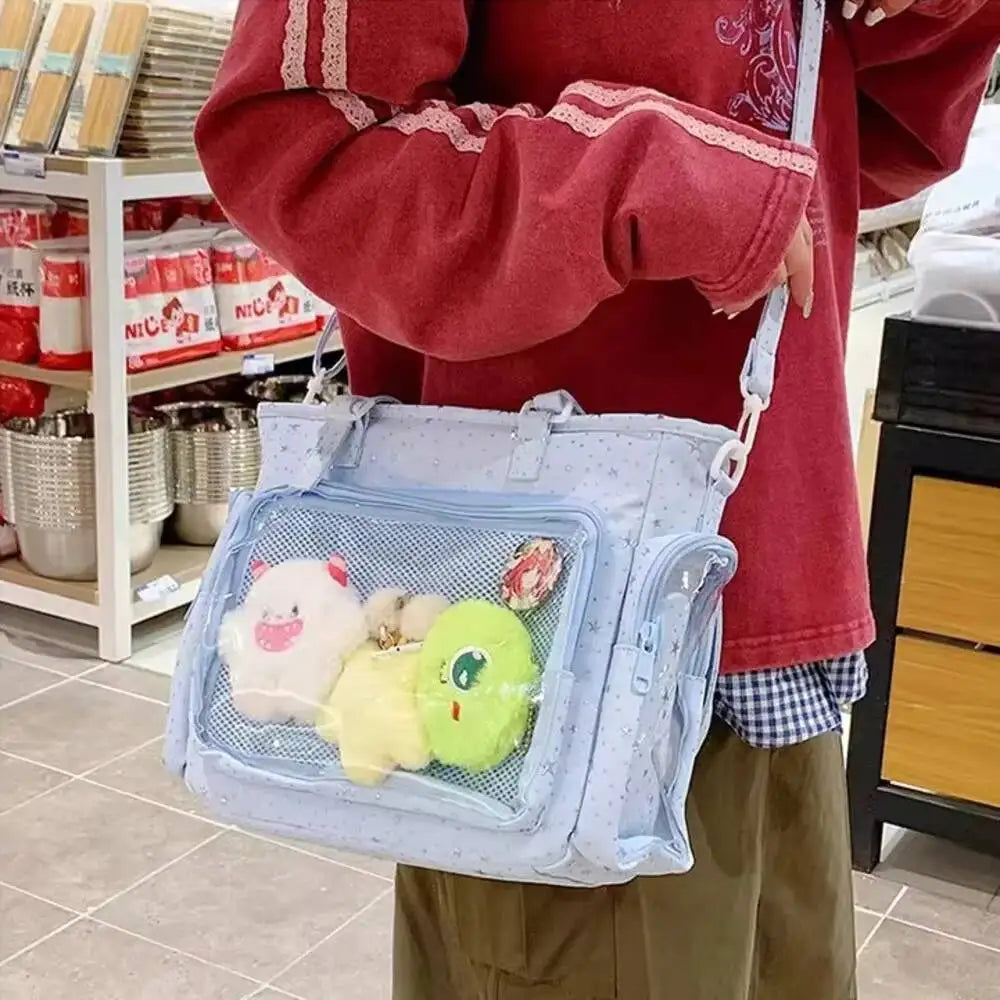 Holds a large transparent Y2K Japanese Ita shoulder bag by HSF Marketplace, featuring a casual, crossbody design for girls.