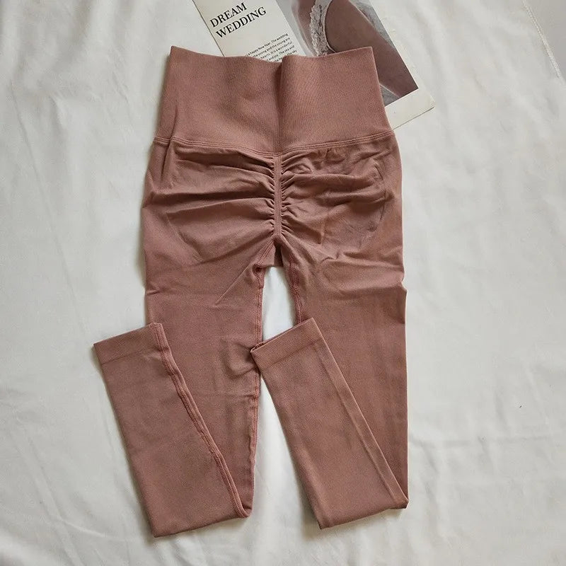 Women's high-waisted seamless leggings with peach butt-lifting fit, shown in a sleek quick-dry fabric for yoga and fitness