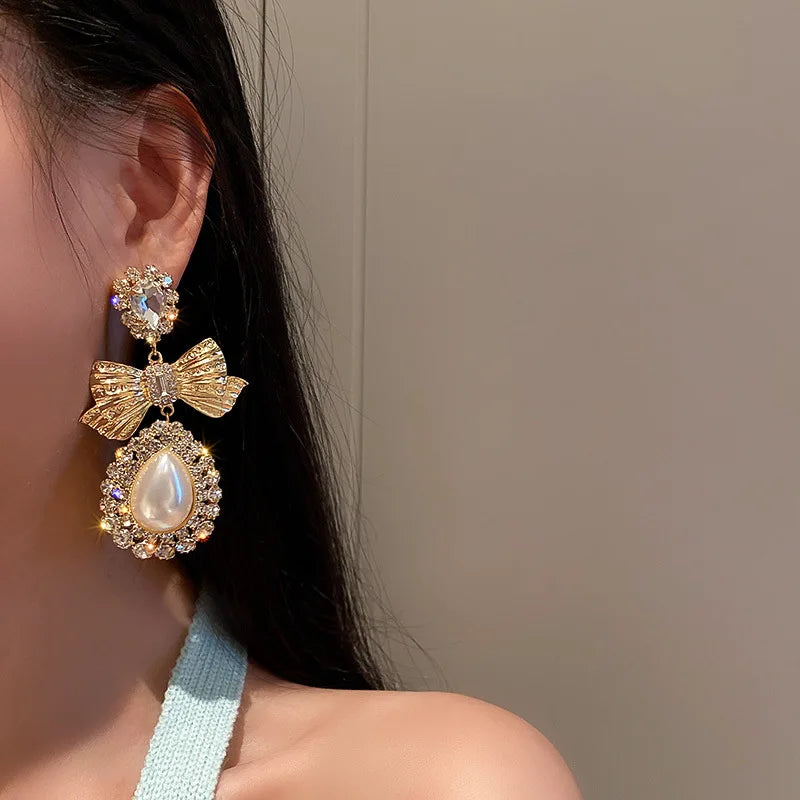 Vintage gold bowknot dangle earrings for women, featuring an elegant oversized bow design
