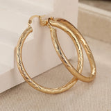 HSF Marketplace classic metal hoop earrings for women with carved pattern, shown in close-up