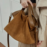 Genuine leather women's handbag with large capacity, shoulder strap, and crossbody style, featuring cowhide construction and spacious design.