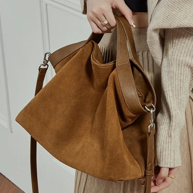 Genuine leather women's handbag with large capacity, shoulder strap, and crossbody style, featuring cowhide construction and spacious design.
