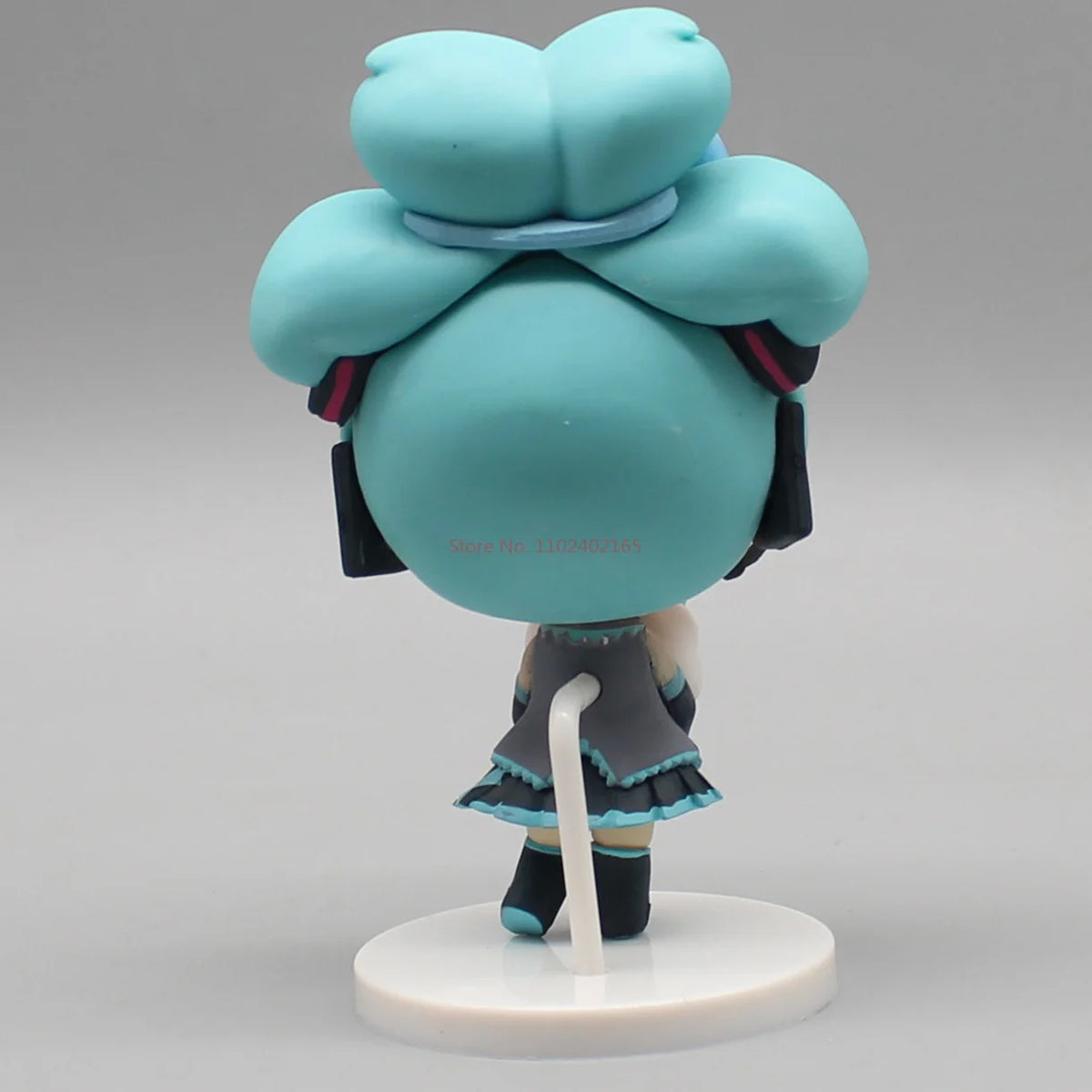 Hatsune Miku anime figurine holding a Cinnamoroll bean-eyed plush, kawaii tabletop collectible toy figure