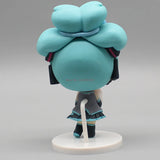 Hatsune Miku anime figurine holding a Cinnamoroll bean-eyed plush, kawaii tabletop collectible toy figure