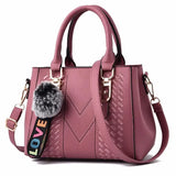 Leather embroidery messenger bag for women with hair ball detail, stylish handbag suitable for daily use.