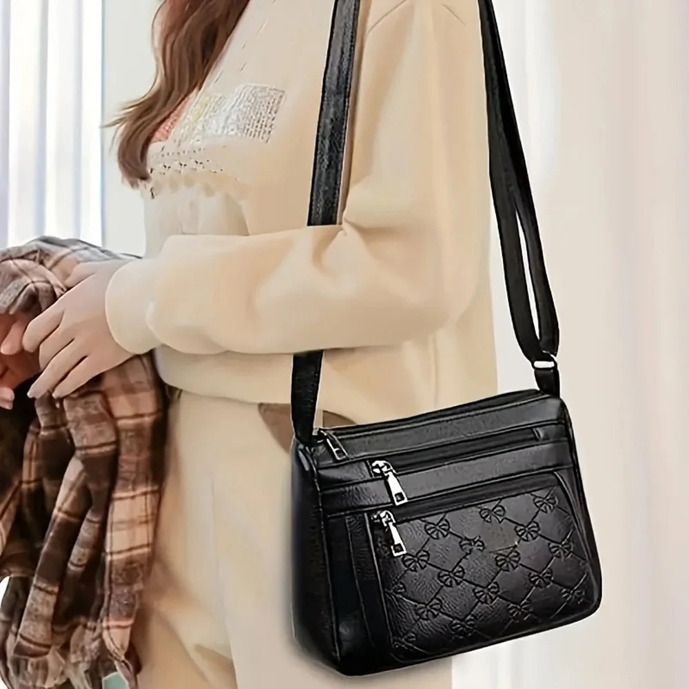 Black embossed women’s crossbody handbag with multiple pockets, PU leather, large capacity, ideal for outings and parties.