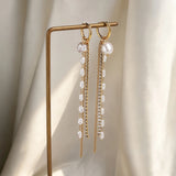 Gold color long tassel dangle earrings for women, HSF Marketplace jewelry beside a model’s ear