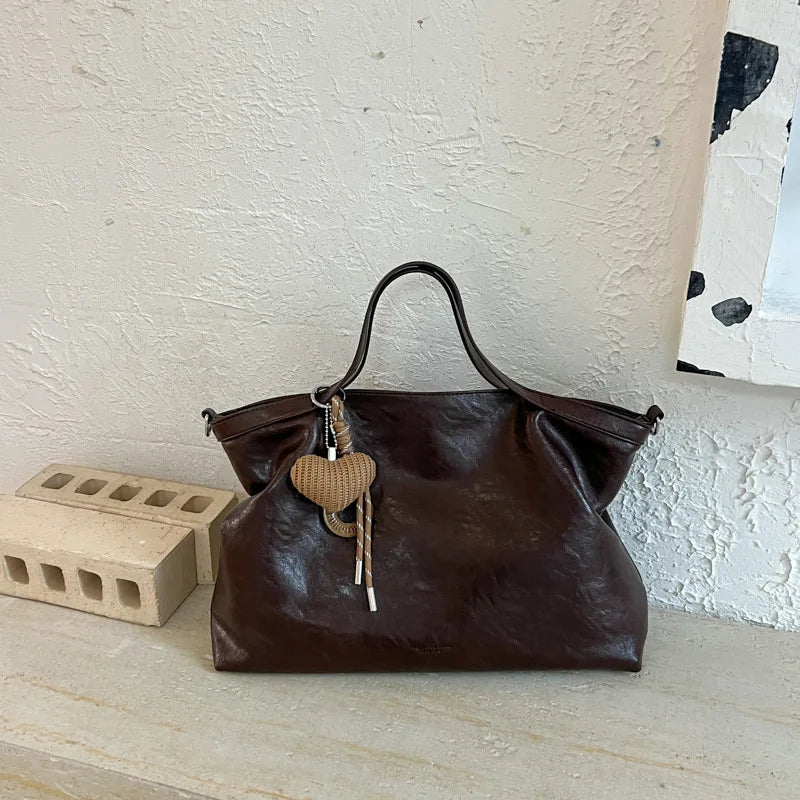 Luxury black PU leather women's handbag with spacious design, shoulder strap, and elegant tote style for commuting and office use.