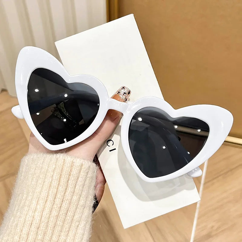 Pink heart-shaped vintage sunglasses for girls, transparent shiny Instagram style eyewear perfect for beach parties and photos.