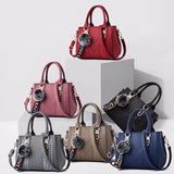 Leather messenger handbag for women with embroidery and hairball design, stylish leather purse for everyday use.