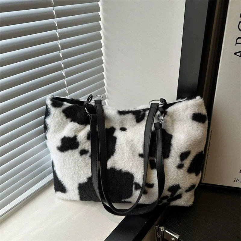 Large capacity women's winter tote bag with cow print plush shoulder design, ideal for travel and everyday use.