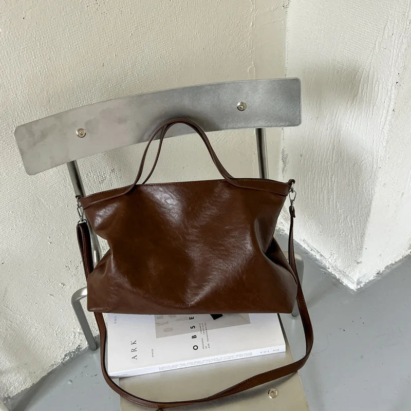 Luxury PU leather women's handbag with spacious design, shoulder strap, and stylish tote for commuting and office use.