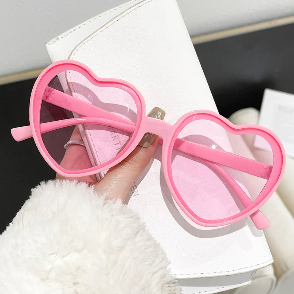 Pink love heart-shaped sunglasses for women with big vintage frames, UV400 protection, stylish outdoor fashion eyewear.