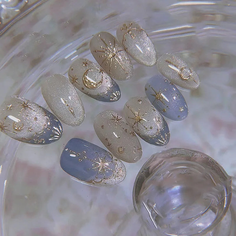 24-piece Y2K star press-on false nails with gradient blue French tips and gold moon designs in a sweet almond shape