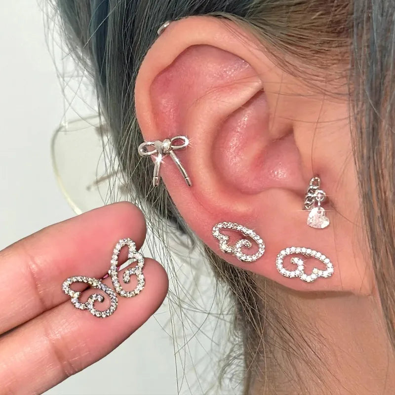 Sparkly full diamond angel wings geometric hollow stud earrings in silver-tone metal, front view