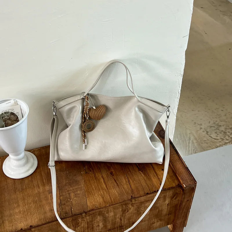 Luxury PU leather women's handbag with spacious design, shoulder strap, and elegant style for commuting and office use.