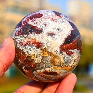 A stunning money agate ball with yellow and blue patterns, perfect for home and garden decoration.