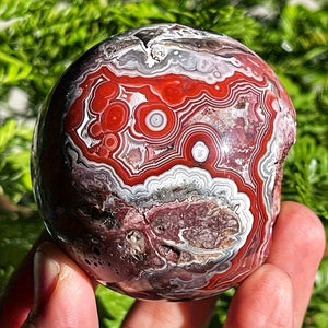 A stunning money agate ball with yellow and blue patterns, perfect for home and garden decoration.